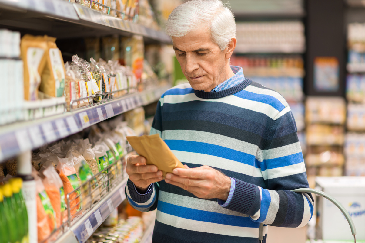 Elderly man shopping cereals in the store